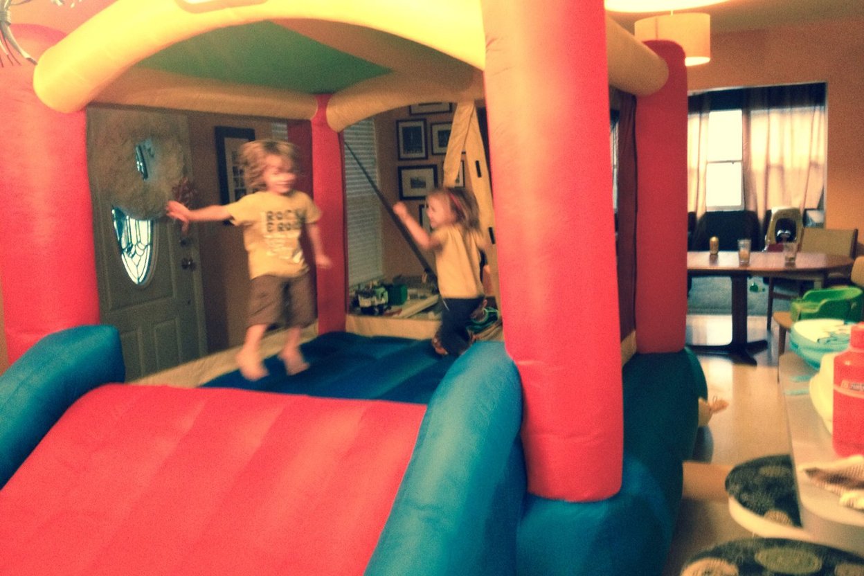 A colorful inflatable bounce house set up inside a gymnasium