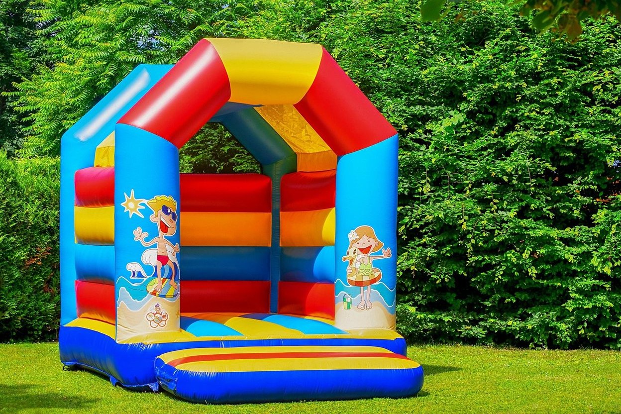 A colorful bouncy castle set up on a grassy lawn