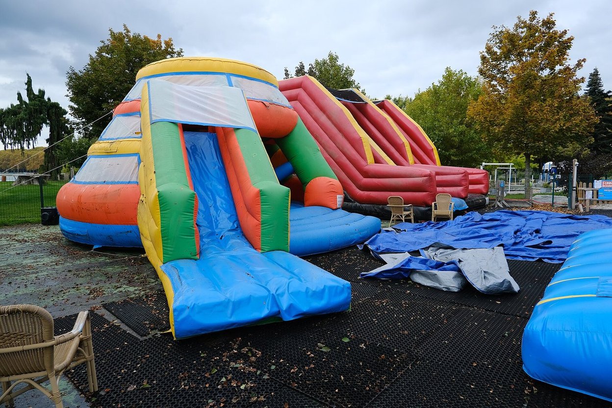 Inflatable slides partly deflated on the ground at a fairground