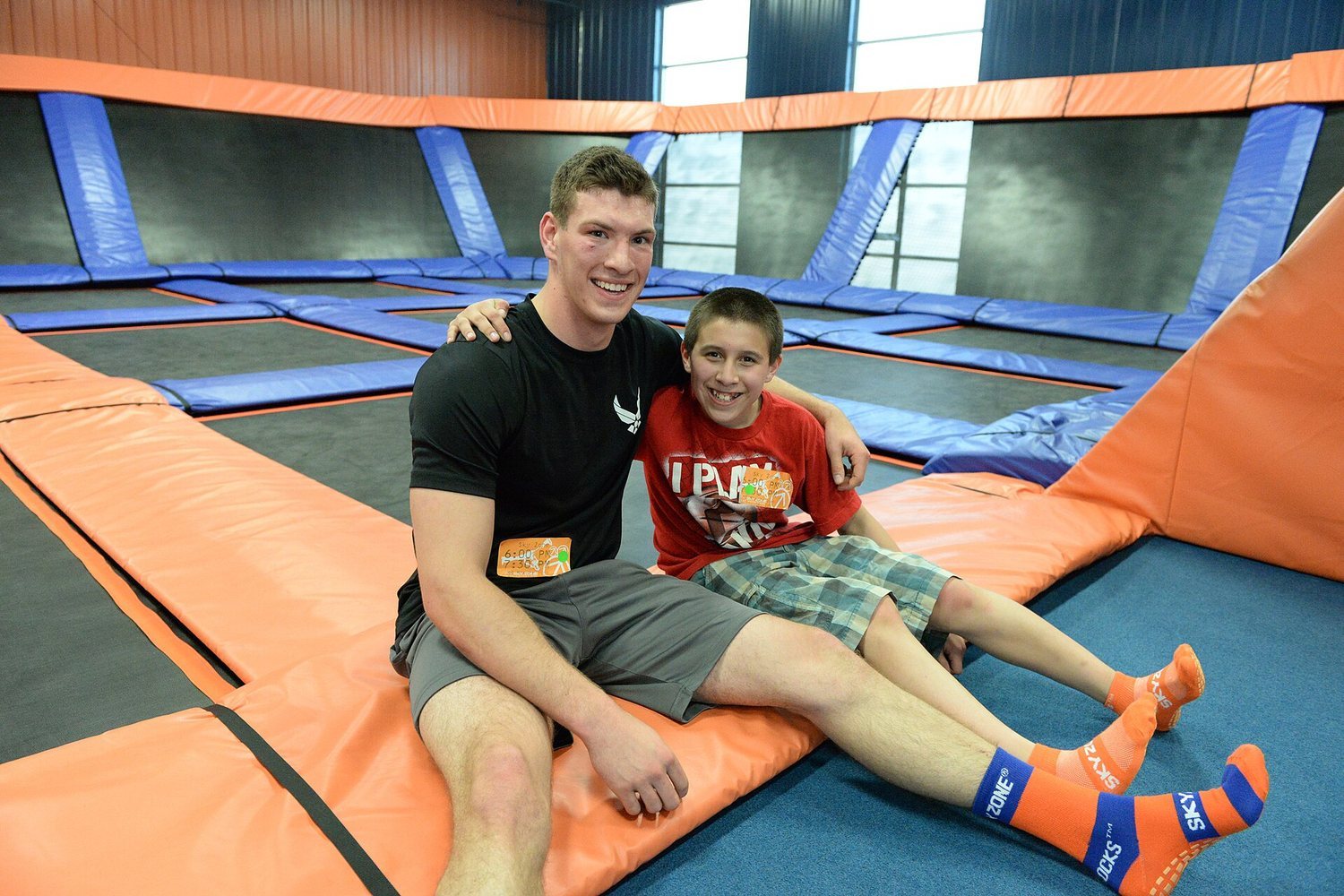 Two people smiling on a trampoline at an indoor park