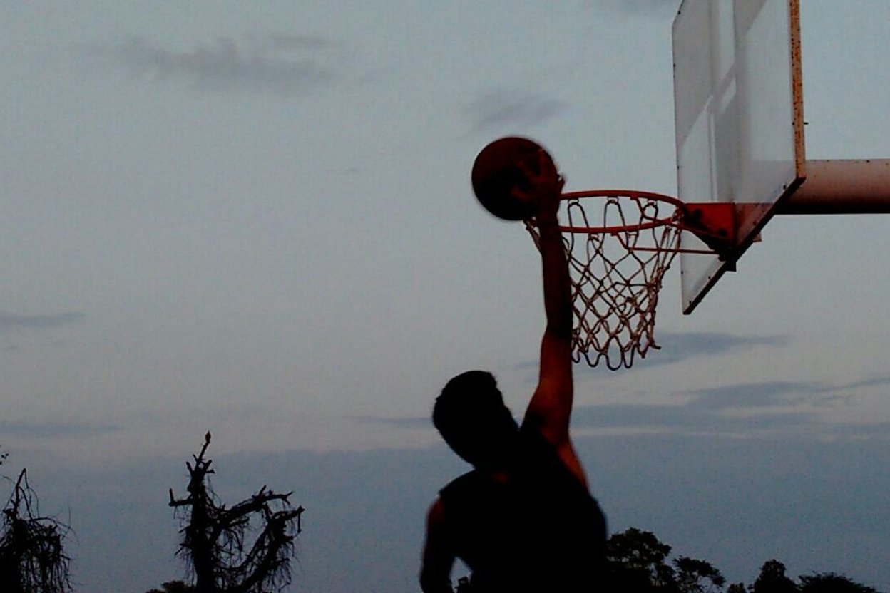 An athlete jumping high on an outdoor court