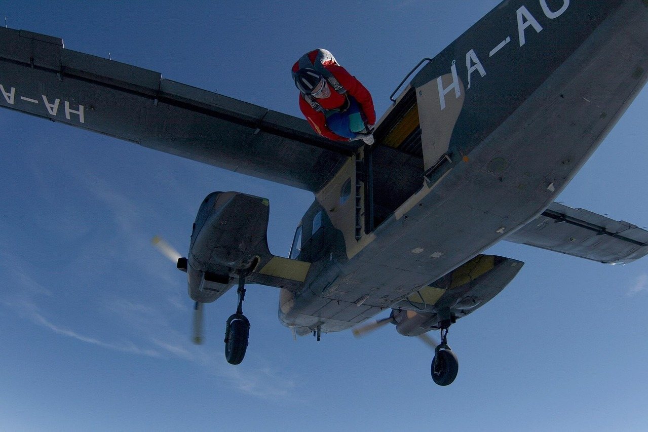 Skydiver jumping from vintage military plane with HA-AO registration