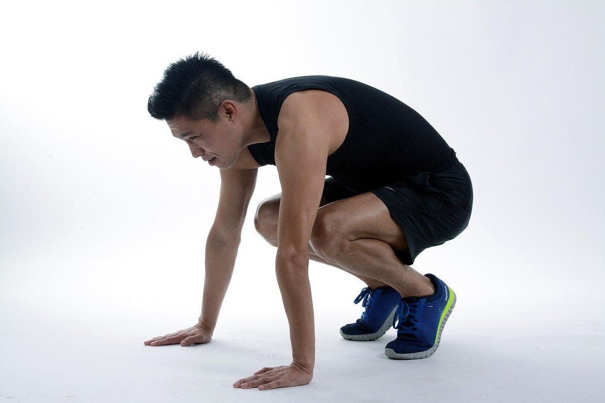 A woman in a deep squat position during a workout