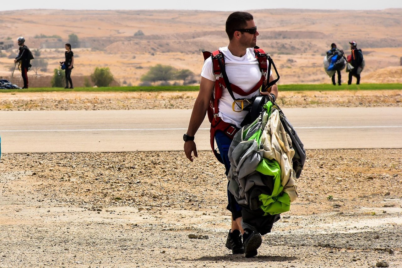 Parachutist carrying gear after landing on a runway
