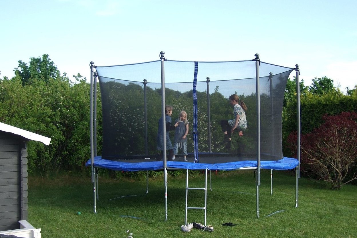 Kids jumping on a backyard trampoline