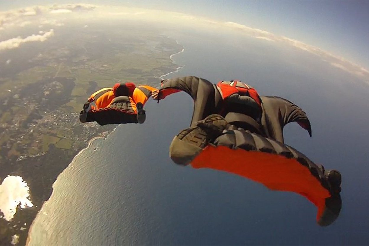 A wingsuit flyer gliding through the sky